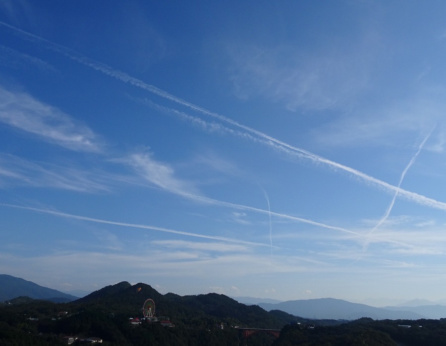 飛行機雲が走る空